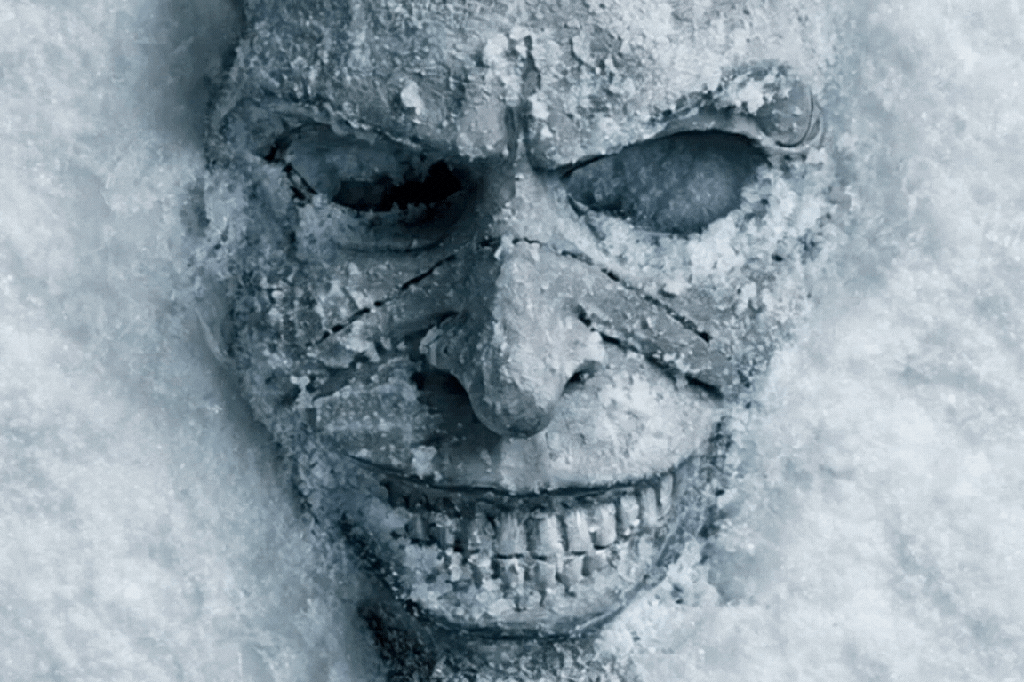 Máscara de sorriso exagerado e macabro enterrada na neve, caem flocos de gelo enquanto a boca sorrindo se abre aos poucos. Máscara de sorriso exagerado e macabro enterrada na neve, caem flocos de gelo enquanto a boca sorrindo se abre aos poucos.